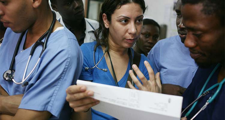 Nurse holding paper and speaking to others